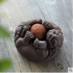 Tea pet in ceramica con rilievi scolpiti — Animali attorno a una sfera rossa