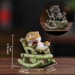 Tea pet rana dorata in resina su poltrona a dondolo